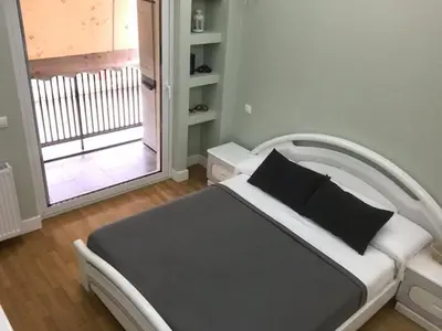 a bedroom with a bed and a door to a balcony at Finer Things Flisvos Beach Condo in Palaio Faliro in Athens