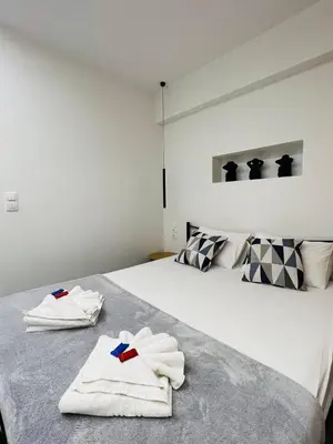 a bedroom with a bed with towels on it at Cozy Corner Dialog Number 2 VIPGreece in Athens