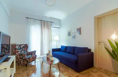 a living room with a blue couch and a chair at Adorable 2 bedroom apartment close to Ancient Athens city center in Athens