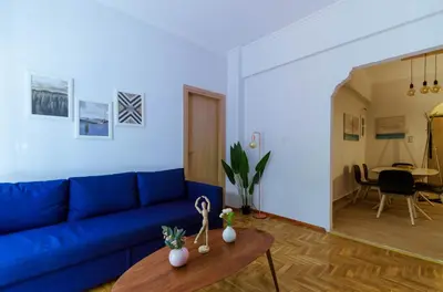 a living room with a blue couch and a table at Adorable 2 bedroom apartment close to Ancient Athens city center in Athens
