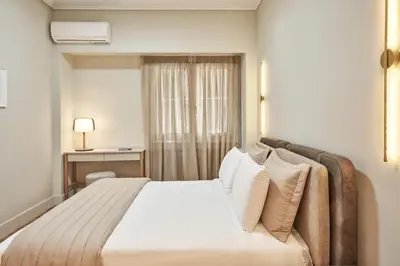 a bedroom with a bed with white sheets and pillows at Athenian Elite Kolonaki Apt in Athens