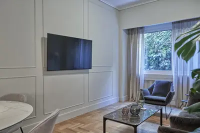 a living room with a tv on a wall at Athenian Elite Kolonaki Apt in Athens