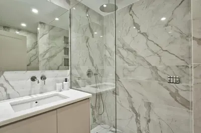 a white bathroom with a shower and a sink at Athenian Elite Kolonaki Apt in Athens