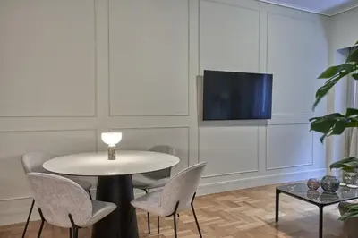 a dining room with a table and chairs and a tv at Athenian Elite Kolonaki Apt in Athens