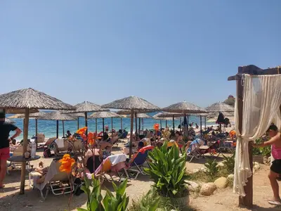 a crowd of people sitting on a beach with umbrellas at Casa Nova - Appartment near the sea in Piraeus