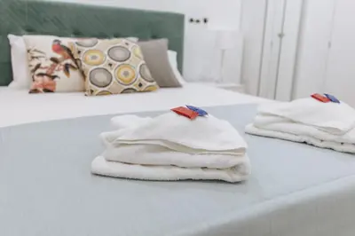 two white towels are stacked on a bed at Your Cozy Sapphire Apartment VIPGreece in Athens