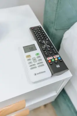 a remote control and a thermometer on a table at Your Cozy Sapphire Apartment VIPGreece in Athens