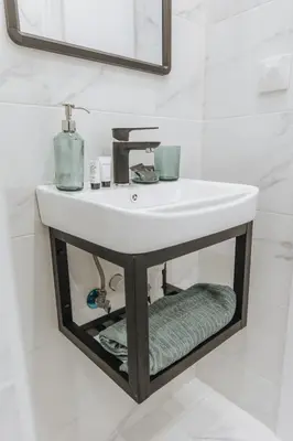 a bathroom with a white sink and a mirror at Your Cozy Sapphire Apartment VIPGreece in Athens