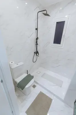 a white bathroom with a toilet and a shower at Your Cozy Sapphire Apartment VIPGreece in Athens