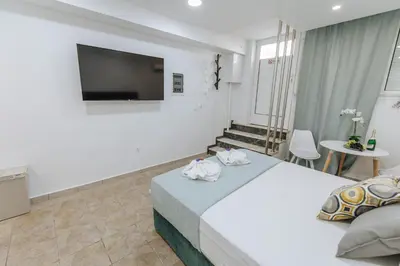 a hotel room with a bed and a flat screen tv at Your Cozy Sapphire Apartment VIPGreece in Athens