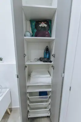 a closet with white shelves and towels at Your Cozy Sapphire Apartment VIPGreece in Athens