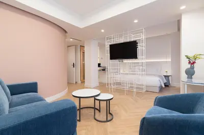a living room with two blue couches and a tv at Altar Suites in Athens