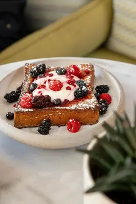 a plate with a piece of toast with berries and cream at Altar Suites in Athens