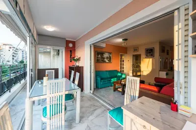 a room with a balcony with a table and chairs at Flisvos Elite Seafront Luxury Apartment in Athens