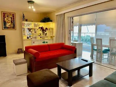 a living room with a red couch and a table at Flisvos Elite Seafront Luxury Apartment in Athens