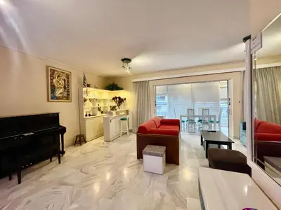 a living room with a red couch and a piano at Flisvos Elite Seafront Luxury Apartment in Athens