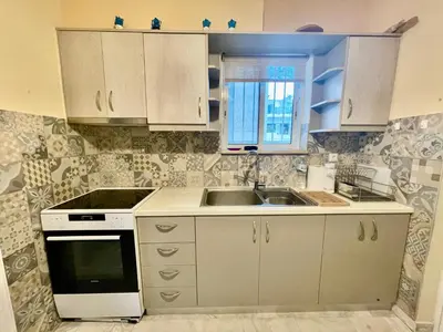 a kitchen with white cabinets and a sink at Flisvos Elite Seafront Luxury Apartment in Athens