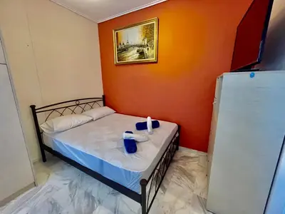 a small bed in a room with an orange wall at Flisvos Elite Seafront Luxury Apartment in Athens
