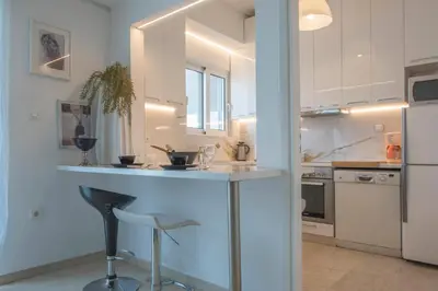 a kitchen with a counter with a bar in it at Maria Louiza apartment close to the center in Athens