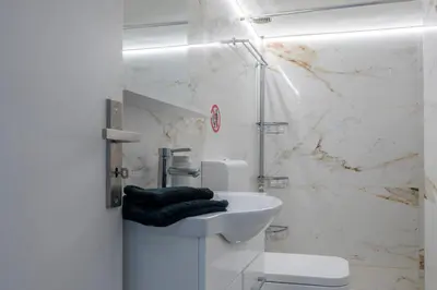 a white bathroom with a sink and a shower at Maria Louiza apartment close to the center in Athens