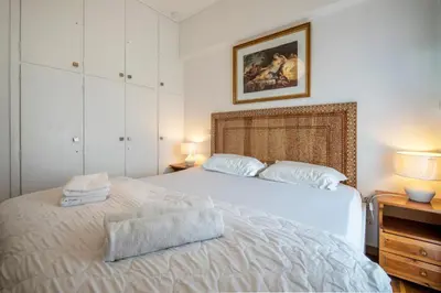 a bedroom with a white bed with two towels on it at Maria Louiza apartment close to the center in Athens