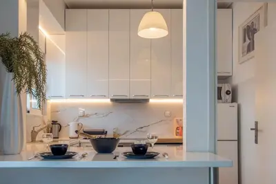 a kitchen with white cabinets and black bowls on a counter at Maria Louiza apartment close to the center in Athens