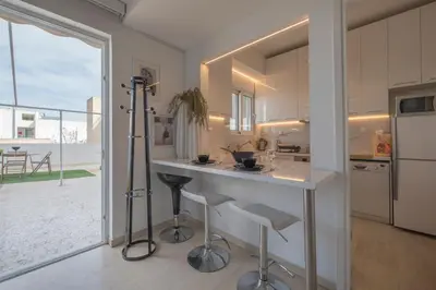a kitchen with a counter with stools and a large window at Maria Louiza apartment close to the center in Athens