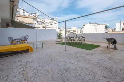 a balcony with a table and chairs and a grill at Maria Louiza apartment close to the center in Athens