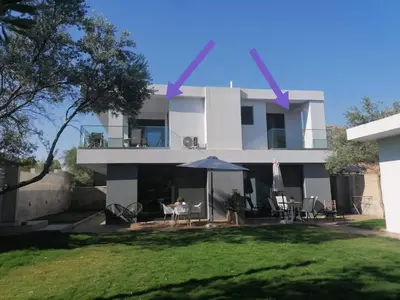 a white house with a table and an umbrella at Greek Dream Homes Thimari in Sounio