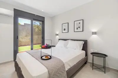 a white bedroom with a bed and a glass table at Greek Dream Homes Thimari in Sounio