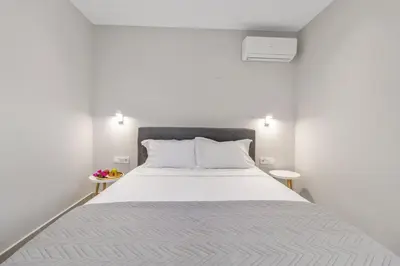 a bedroom with a large white bed with two tables at Greek Dream Homes Thimari in Sounio