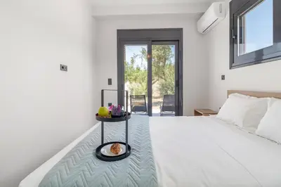 a bedroom with a white bed with a tray of food on it at Greek Dream Homes Thimari in Sounio