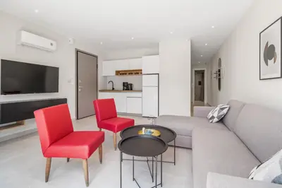 a living room with a couch and red chairs at Greek Dream Homes Thimari in Sounio