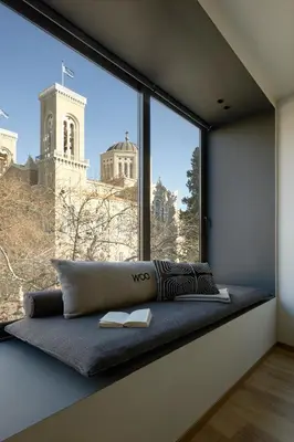 a room with a window seat with a book at Athens Woo Suites in Athens