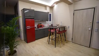 a kitchen with a red refrigerator and a table with stools at New Ventiri Suite 3, near Hilton, Athens Central, fully equipped in Athens