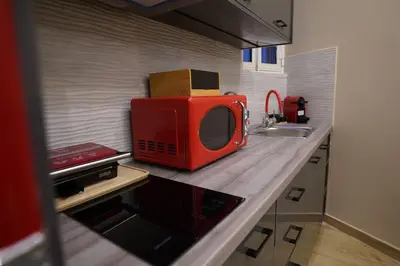 a red microwave sitting on a counter in a kitchen at New Ventiri Suite 3, near Hilton, Athens Central, fully equipped in Athens