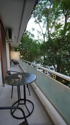 a table on a balcony with a view of trees at New Ventiri Suite 3, near Hilton, Athens Central, fully equipped in Athens