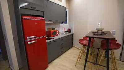 a red refrigerator in a kitchen with a table at New Ventiri Suite 3, near Hilton, Athens Central, fully equipped in Athens