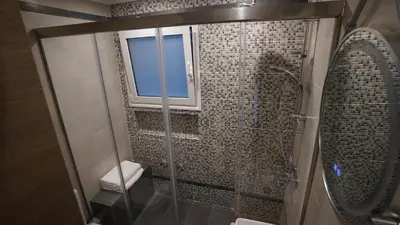 a bathroom with a glass shower with a window at New Ventiri Family Suite 1, near Hilton, Athens central, fully equipped in Athens