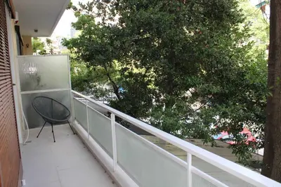 a chair sitting on a balcony with a tree at New Ventiri Family Suite 1, near Hilton, Athens central, fully equipped in Athens