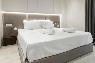 a large white bed with two white towels on it at Ultra Chic Modern 4 Bedrooms Apartment in Athens in Athens