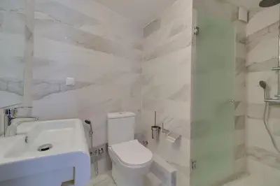 a white bathroom with a toilet and a sink at AthINN Residence in Athens