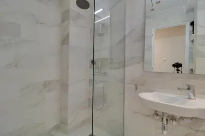 a white bathroom with a sink and a shower at AthINN Residence in Athens