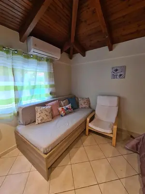 a living room with a couch and a chair at Semelia's Guest house in Spáta