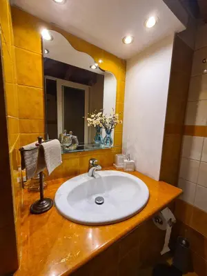 a bathroom with a sink and a mirror at Semelia's Guest house in Spáta