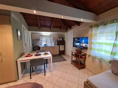 a living room with a table and a kitchen at Semelia's Guest house in Spáta