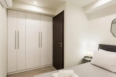 a bedroom with white cabinets and a black door at 2BDR Athens Riviera Sea View Apartment by The Olon in Athens