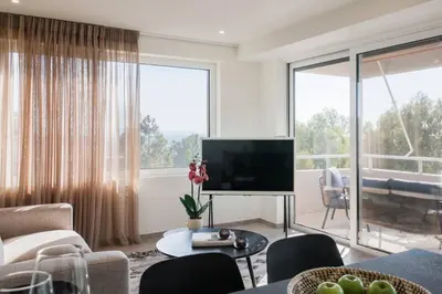 a living room with a television and a large window at 2BDR Athens Riviera Sea View Apartment by The Olon in Athens