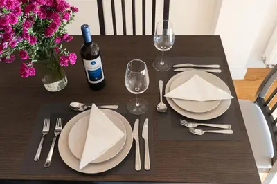a wooden table with plates and silverware and a bottle of wine at Wonderful Central Athens 2 Bedroom 2 Bath Sleeps 8 in Athens
