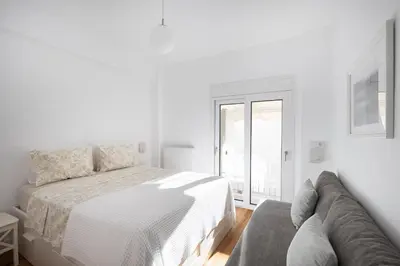 a white bedroom with a bed and a couch at Wonderful Central Athens 2 Bedroom 2 Bath Sleeps 8 in Athens